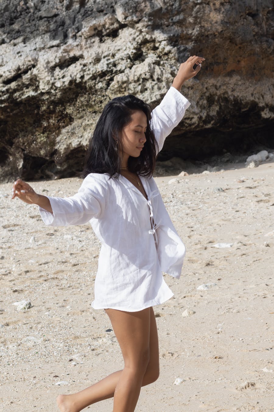 Girl dancing on beach with sustainable clothing